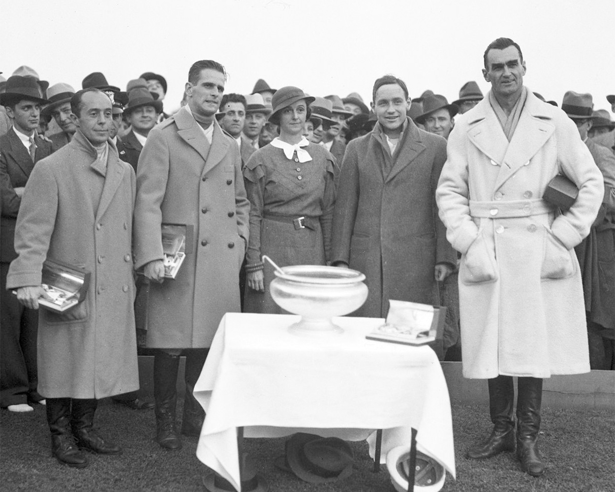 Early English polo players wearing belted camel wool coats after matches