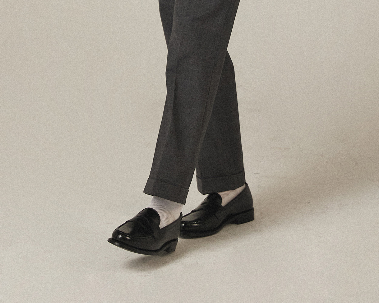 Turn-up cuff detail on Renacts grey pipe-stem trousers