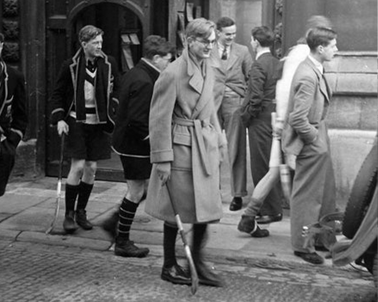Ivy League students wearing camel polo coats with flannel trousers on campus in the 1950s