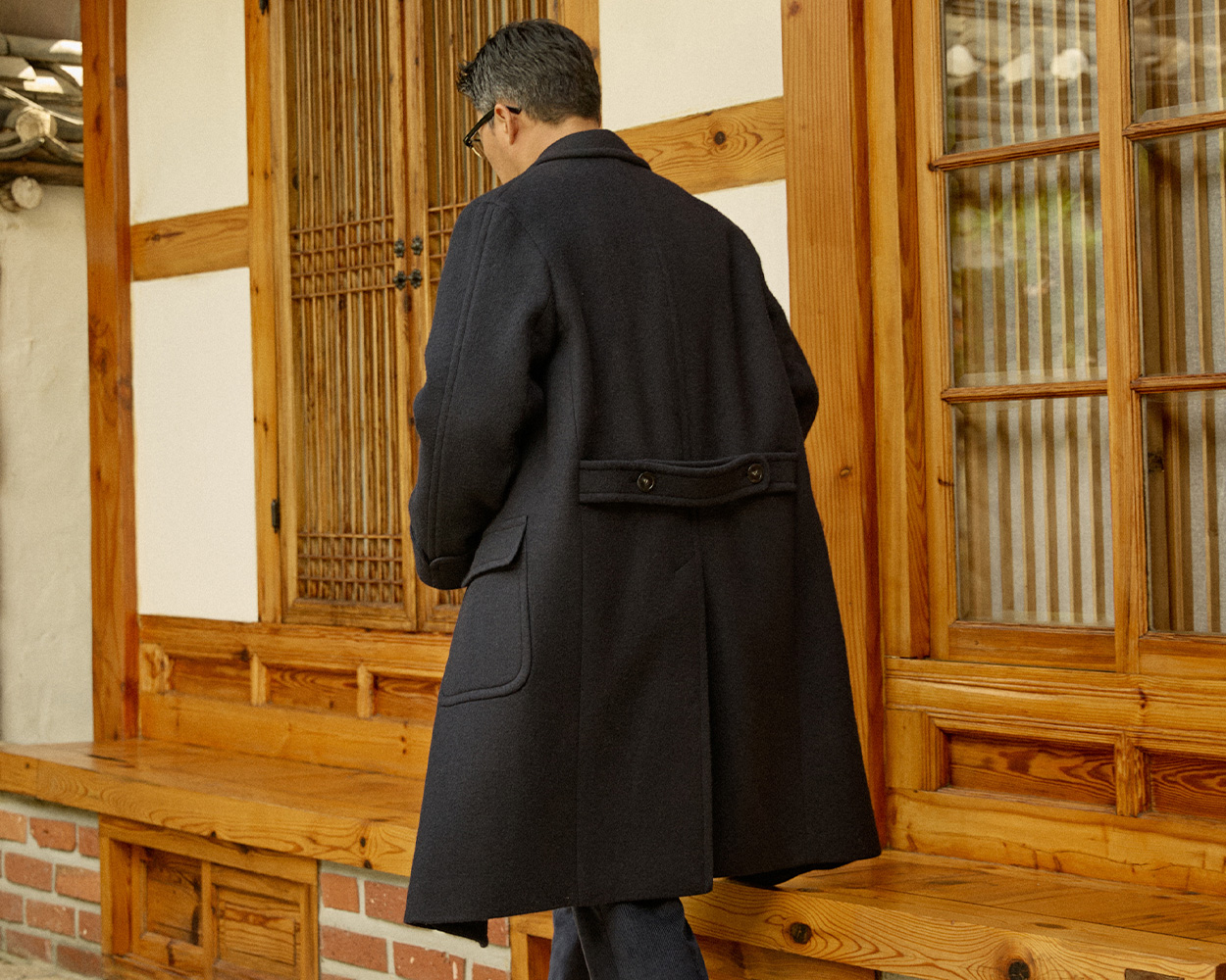 Renacts polo coat silhouette with natural shoulders and belted back in modern Ivy proportions