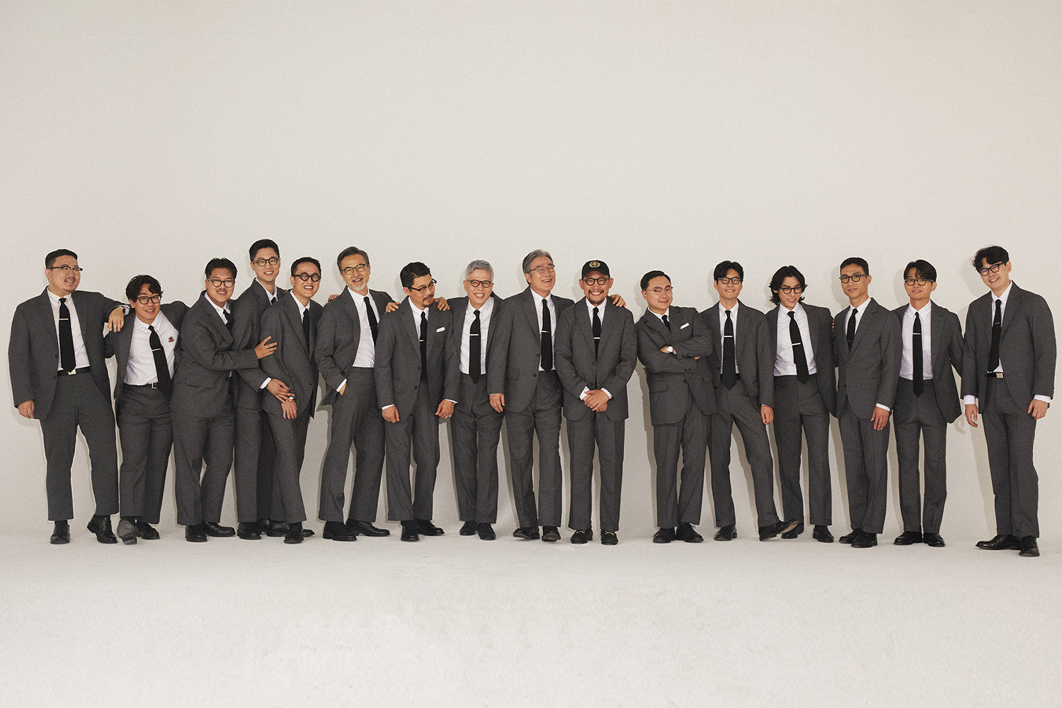 15 member of community guys wear same grey sack suit