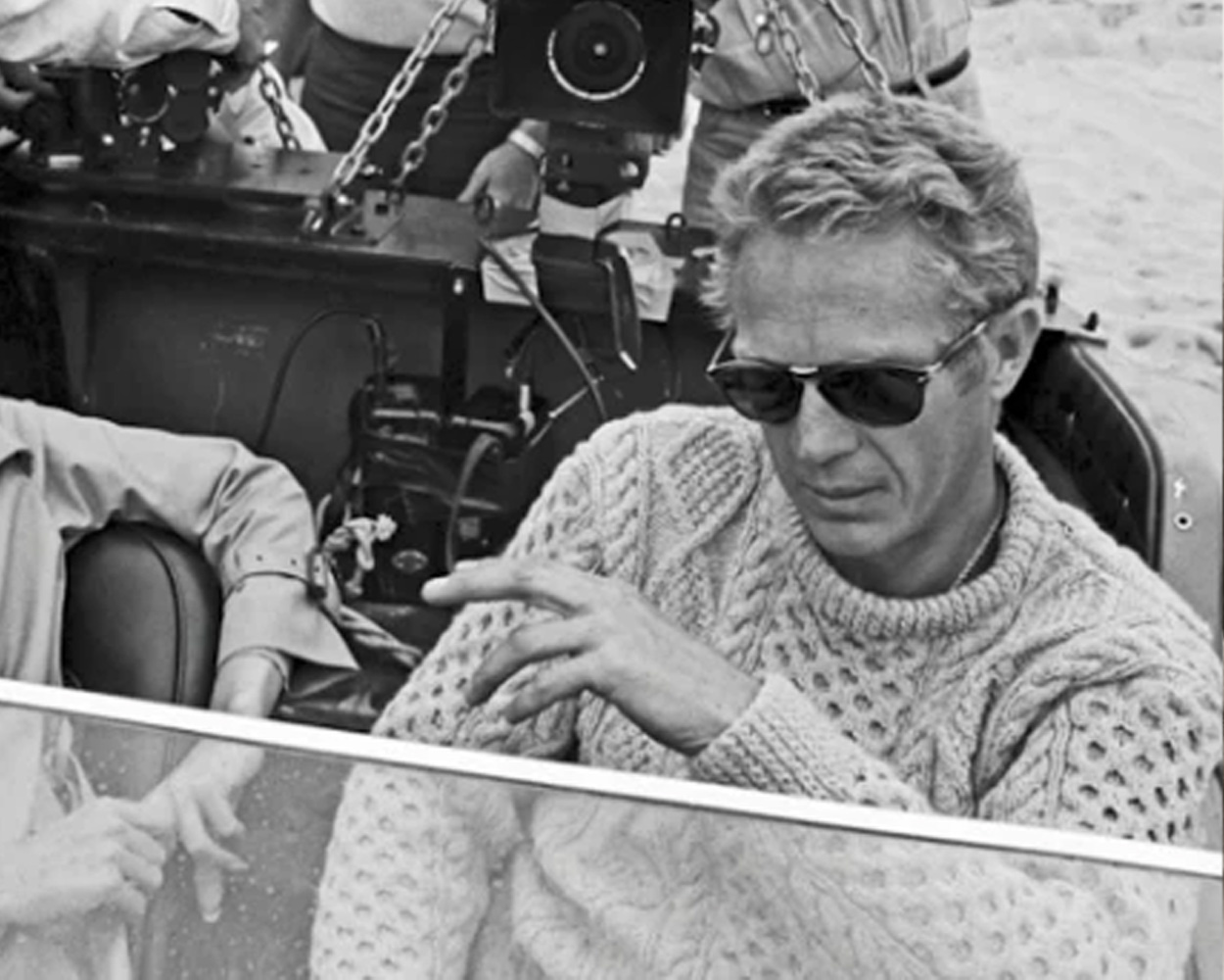 Steve McQueen wearing an ivory cable knit sweater in a classic setting