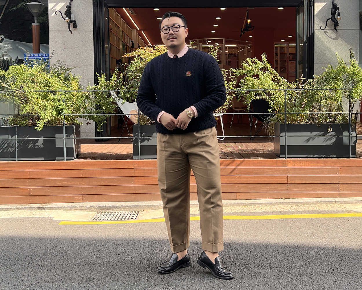 Cable knit sweater paired with beige chinos in classic Ivy menswear