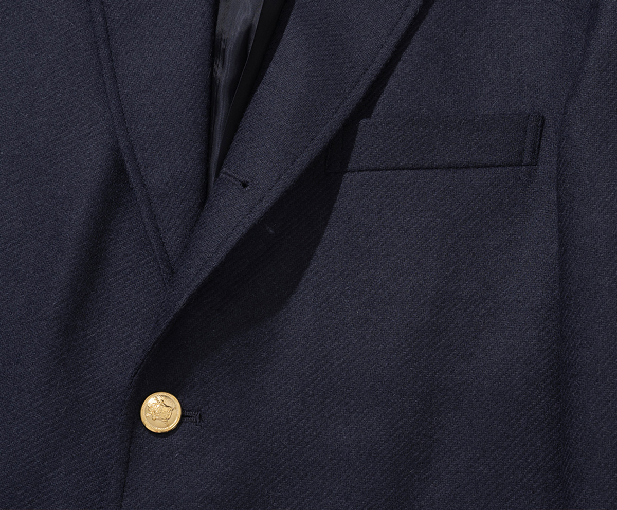 Detail of the three-roll-two buttoning where the top button rolls into the lapel.