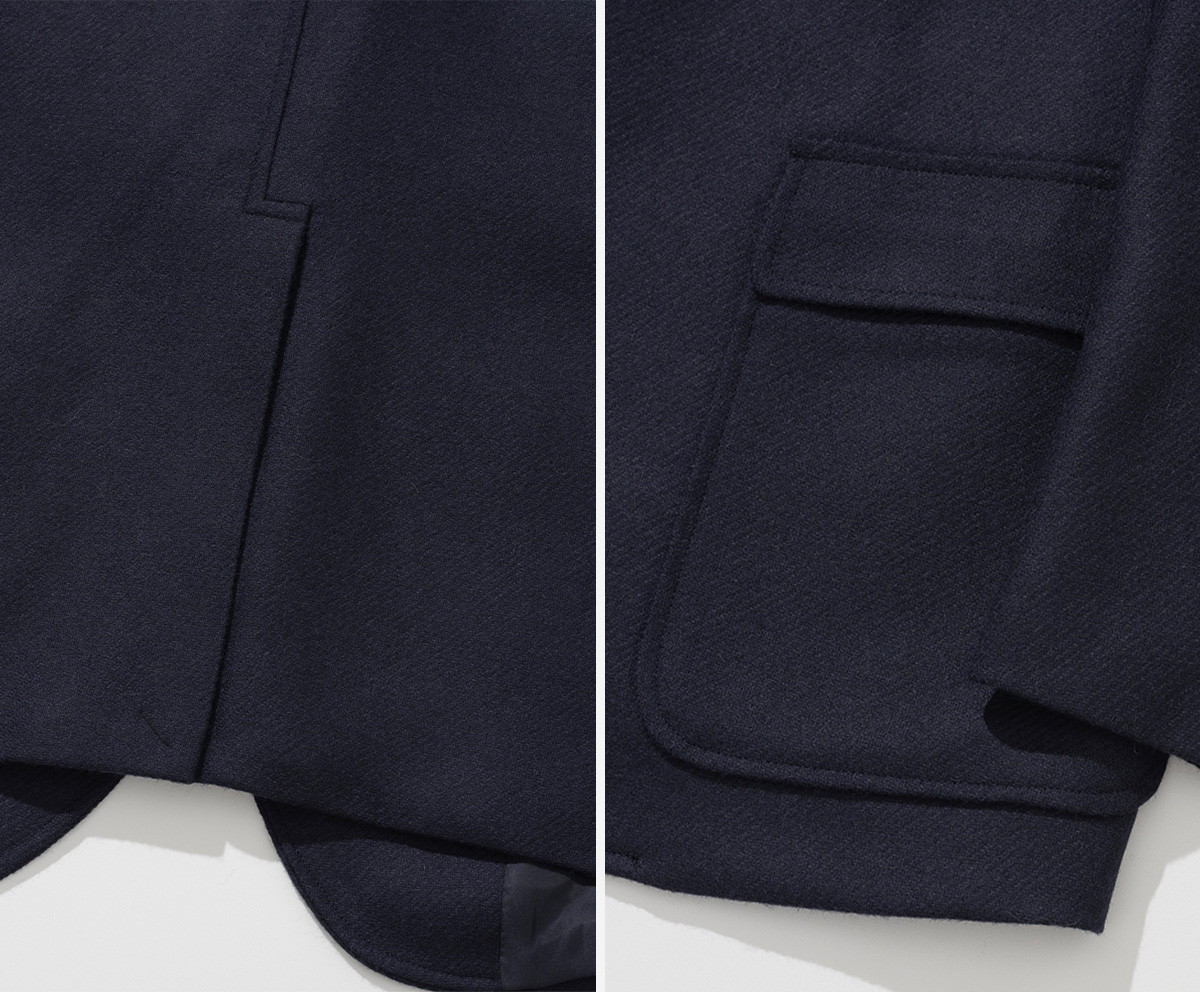 View of the unique hook vent detail on the back and patch pockets on the side of a jacket.