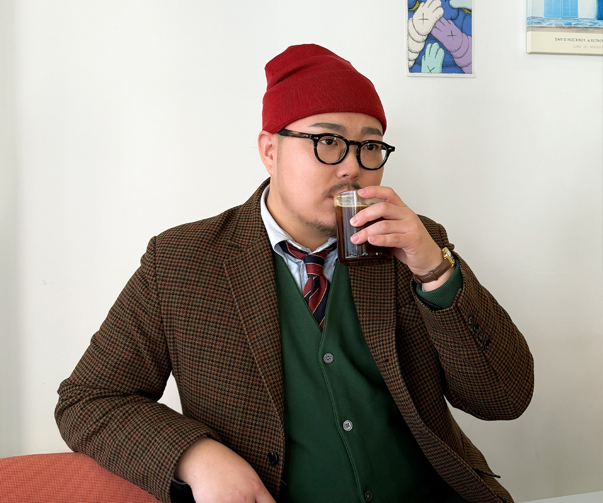 A sensible layered style featuring a cardigan and a sports jacket over a collared shirt.