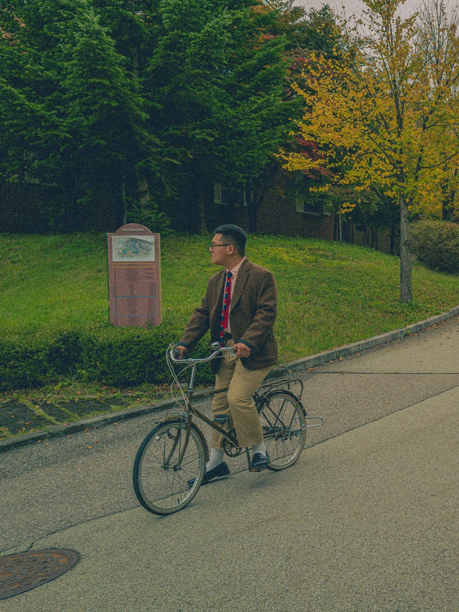 1960s Ivy League student wearing a knit tie casually with rolled sleeves on an American campus