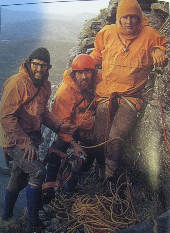 Anorak jacket history — 1970s climbing team in bright orange cagoule anoraks with ropes on a rocky outcrop