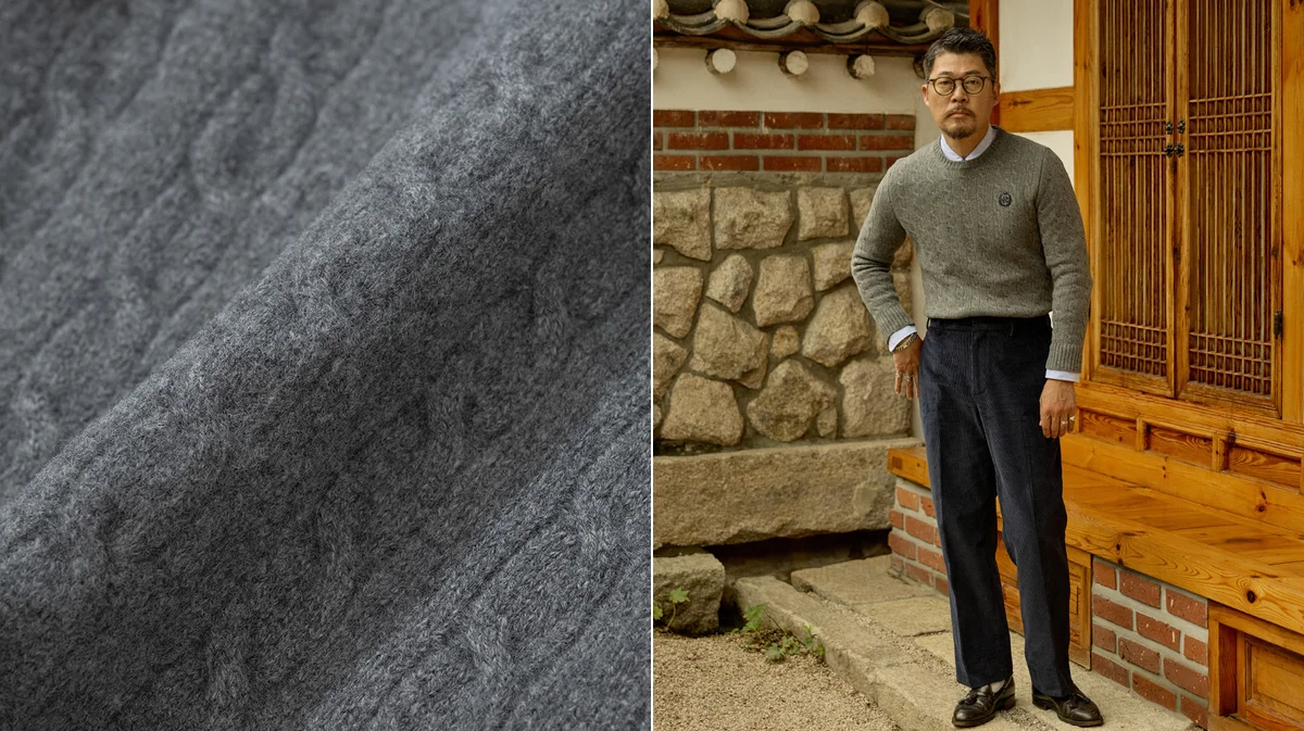 Navy crewneck sweater layered over an OCBD with collar points visible above the neckline