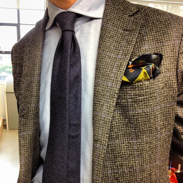 Drake's of London history: close-up of a Drake's silk tie showing the rolled hand-finished blade, English madder weave, and the brand's signature heavy interlining
