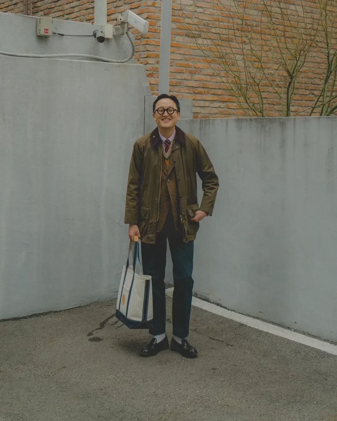 How to wear a Fair Isle vest with country heritage outerwear: Barbour Beaufort wax jacket over Gun Club sport coat over Fair Isle vest, navy chinos, black penny loafers, canvas tote