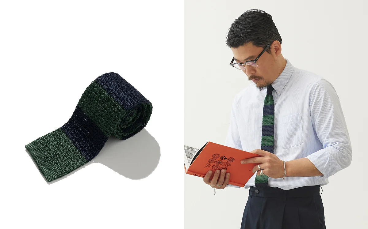 Crewneck sweater layered over a shirt and knit tie with just the knot visible above the neckline