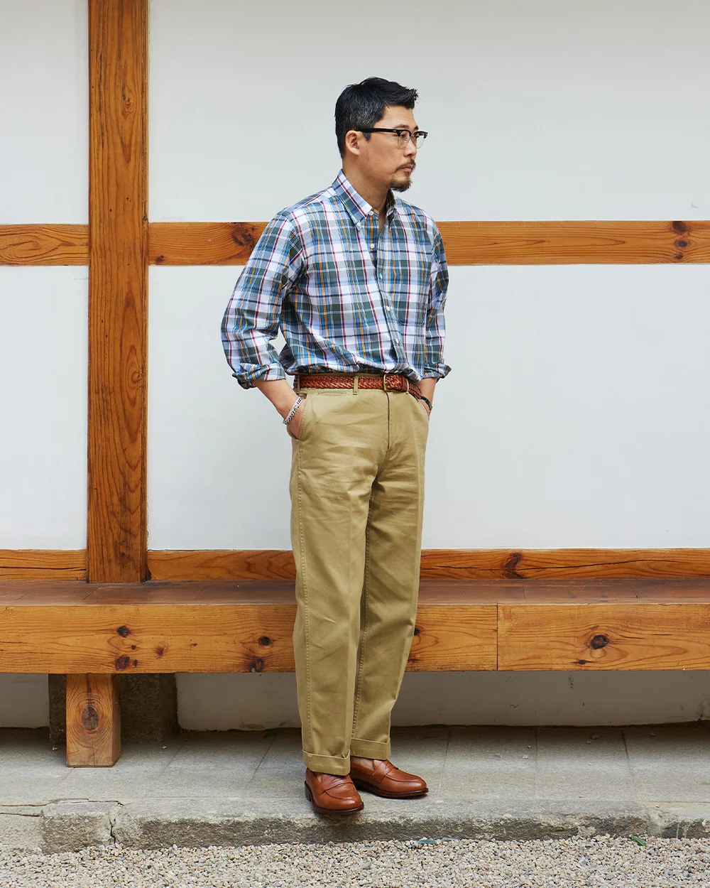 How to wear madras shirt — blue and teal madras with khaki chinos and brown loafers at a hanok wall