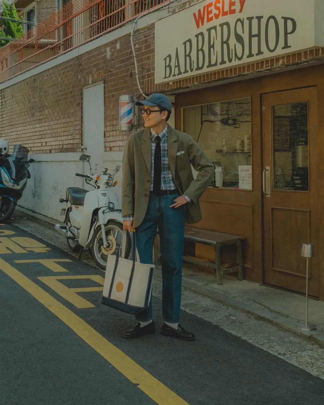 How to wear madras shirt with tie — olive blazer, madras, knit tie, denim at a Wesley Barbershop