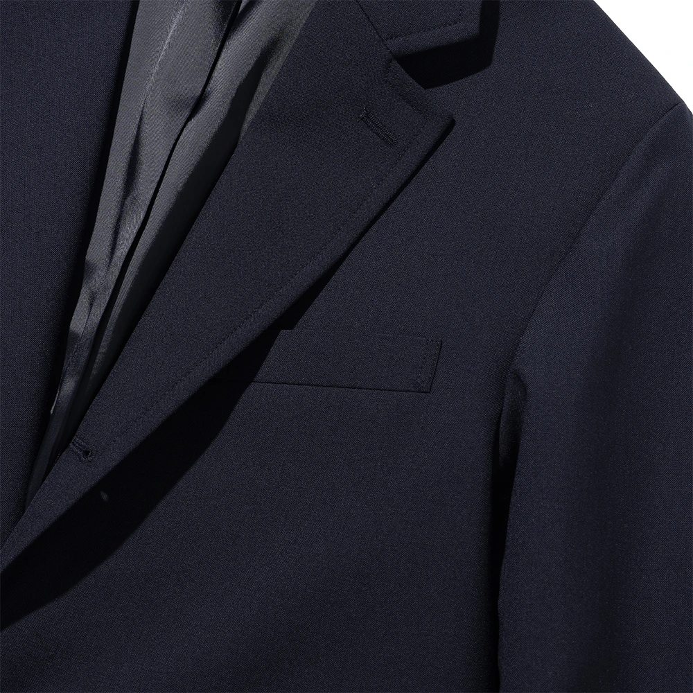 Renacts navy gold-button blazer shoulder area close-up — soft American sack-cut sleeve attachment with no roping at the cap, lapel rolling cleanly into the shoulder line, satin lining visible