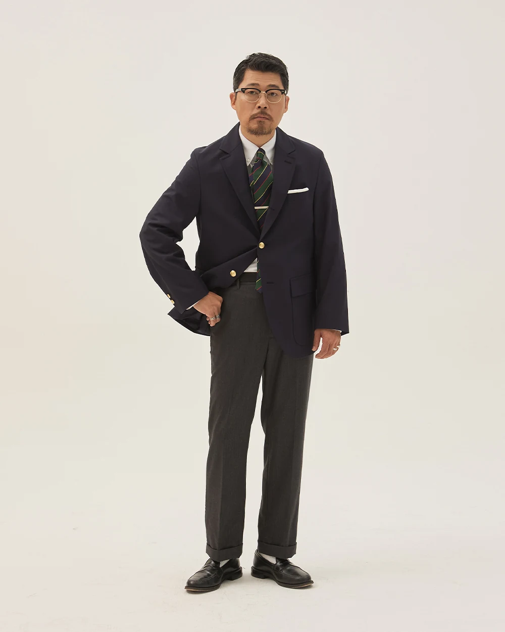 Navy gold-button blazer outfit — Renacts 3/2 roll single-breasted blazer, white OCBD, regimental rep tie (green/red/navy stripe), charcoal grey wool slacks, plaque belt, black penny loafers, classic academic look