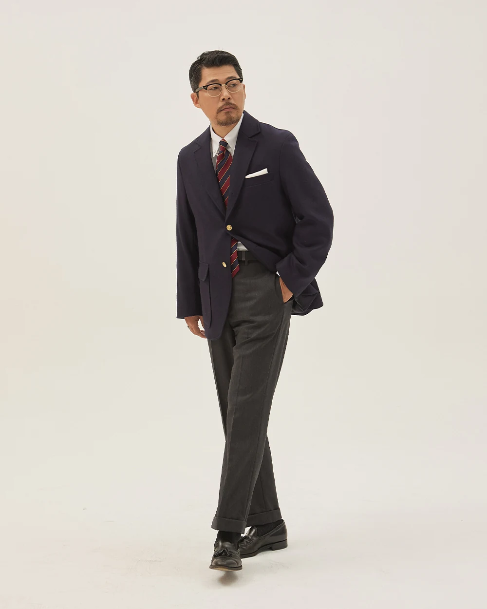 Navy gold-button blazer outfit — single-breasted blazer, white OCBD, regimental rep tie, charcoal grey wool slacks, plaque belt, black tassel loafers, academic register variant with tassel loafers