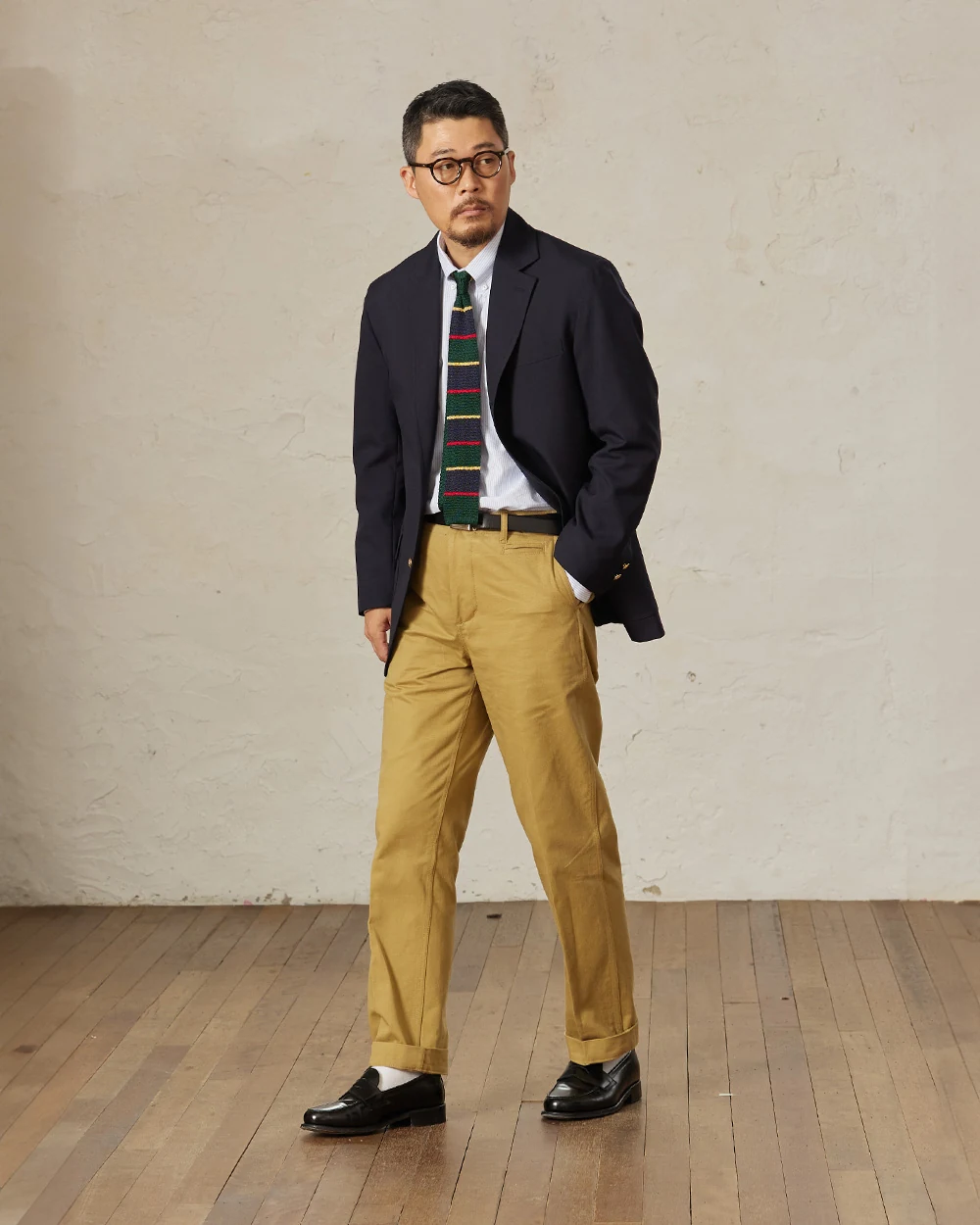 Navy gold-button blazer outfit — single-breasted blazer, white OCBD, knit regimental rep tie, khaki chinos, plaque belt, black penny loafers, knit tie variant of preppy