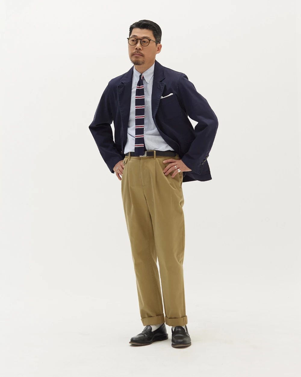Navy gold-button blazer outfit — knit regimental tie, khaki chino, black penny loafers, alternate styling and posture