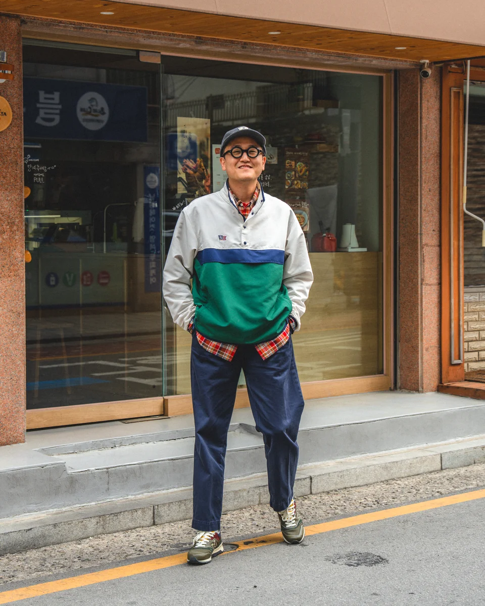 Navy chino pants outfit — anorak, madras shirt, and ballcap on a Seoul street