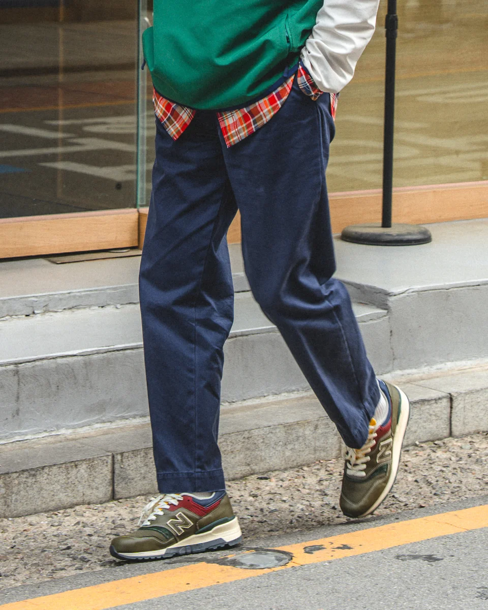 Navy chino pants outfit — ballcap, anorak, and madras shirt detail