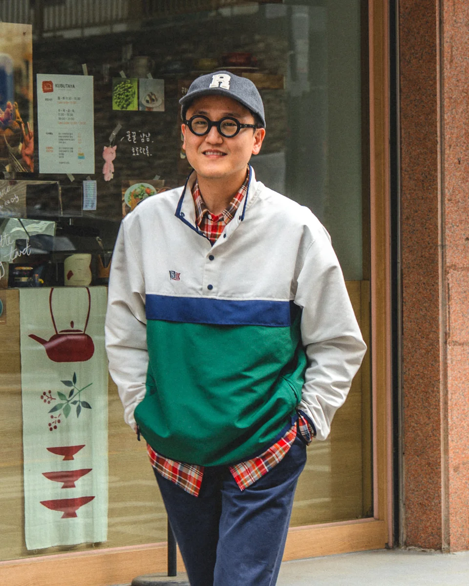 Navy chino pants outfit — full anorak and madras layered street look