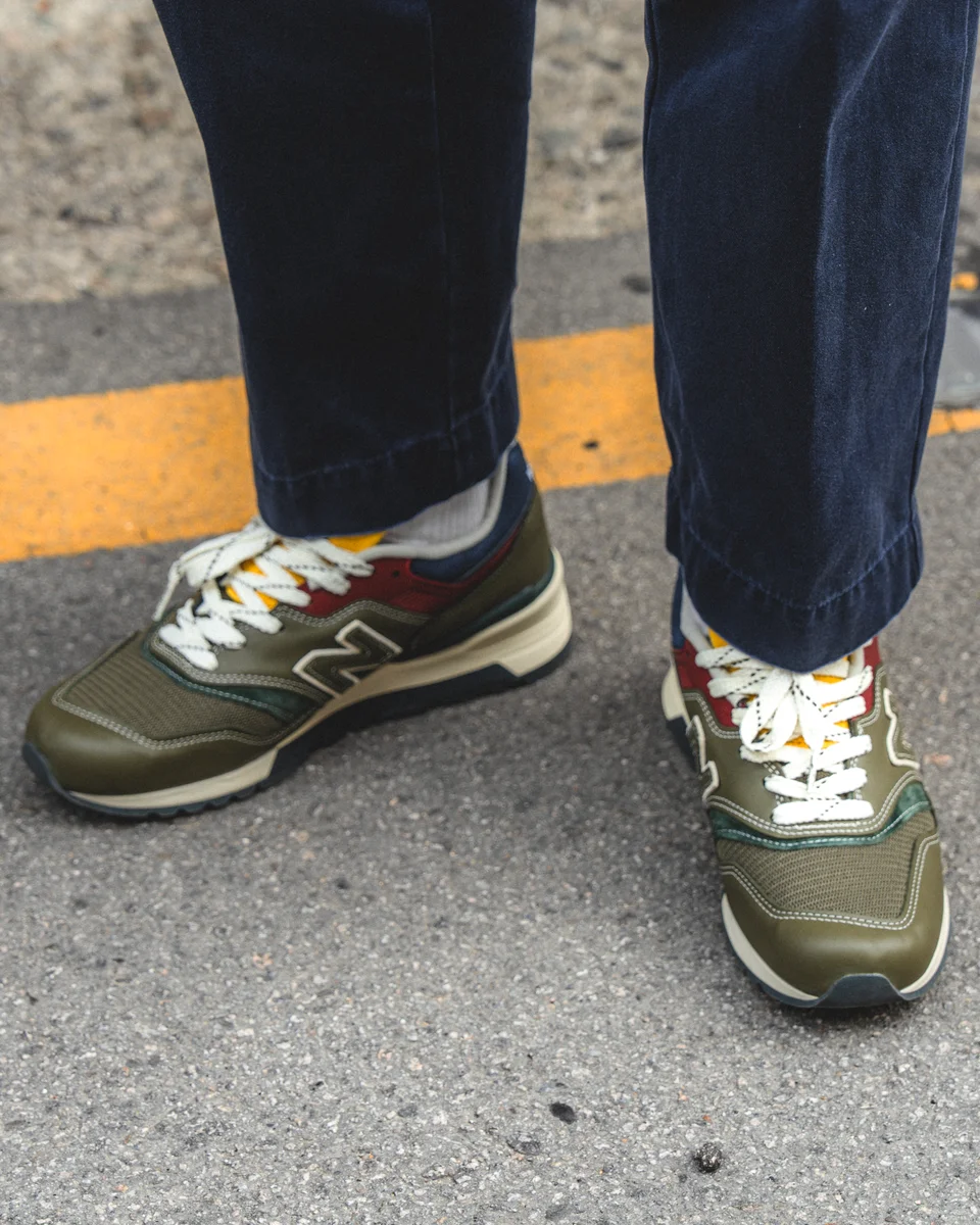 Navy chino pants outfit — full styled look with anorak, madras, and sneakers