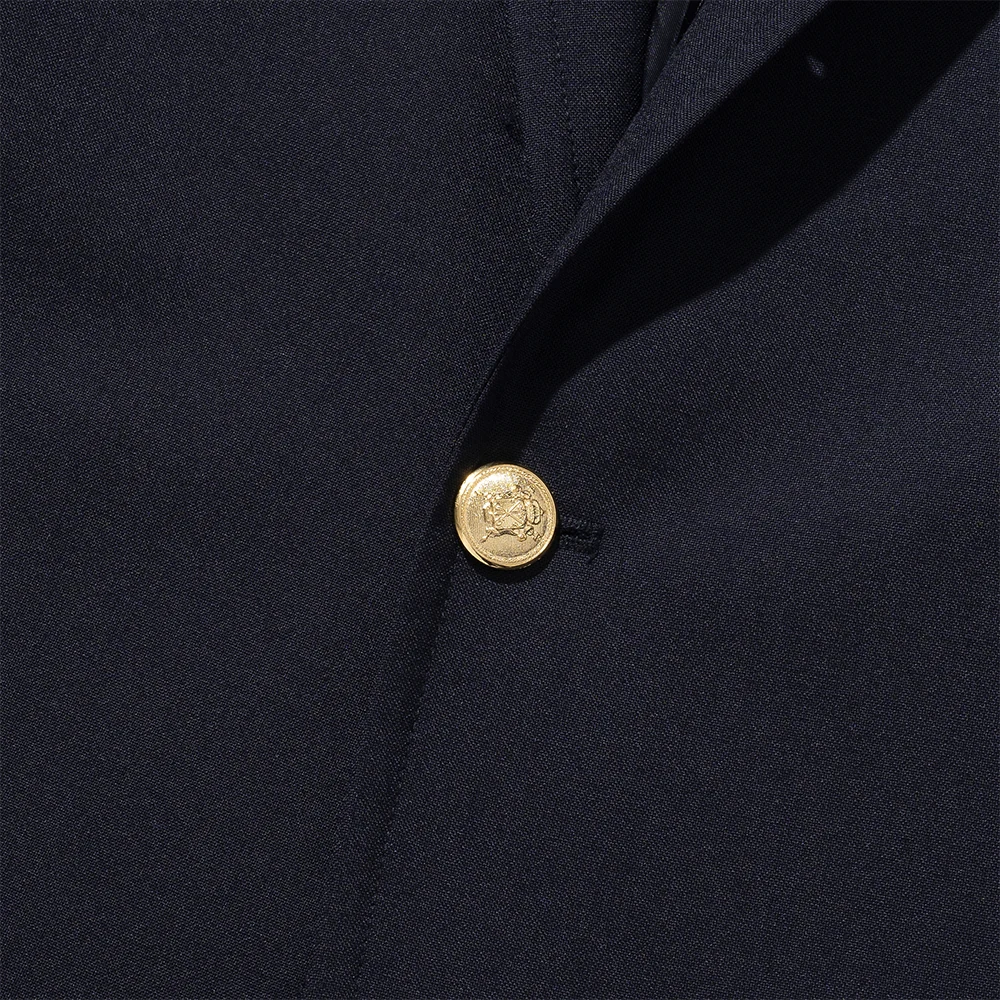 Renacts navy gold-button blazer single gold button macro close-up — classic profile portrait stamping on brushed gold metal