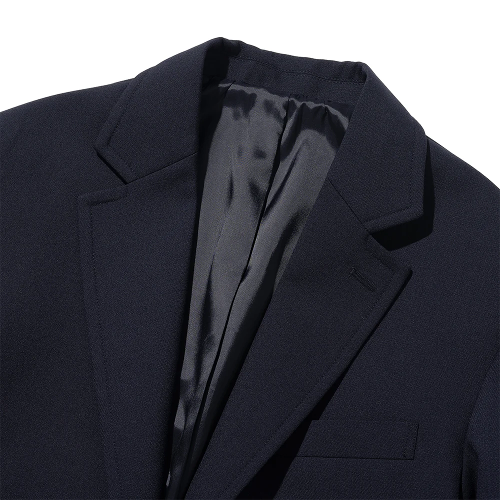 Renacts navy gold-button blazer notch lapel detail — clean rolled edge, satin lining visible inside the lapel break