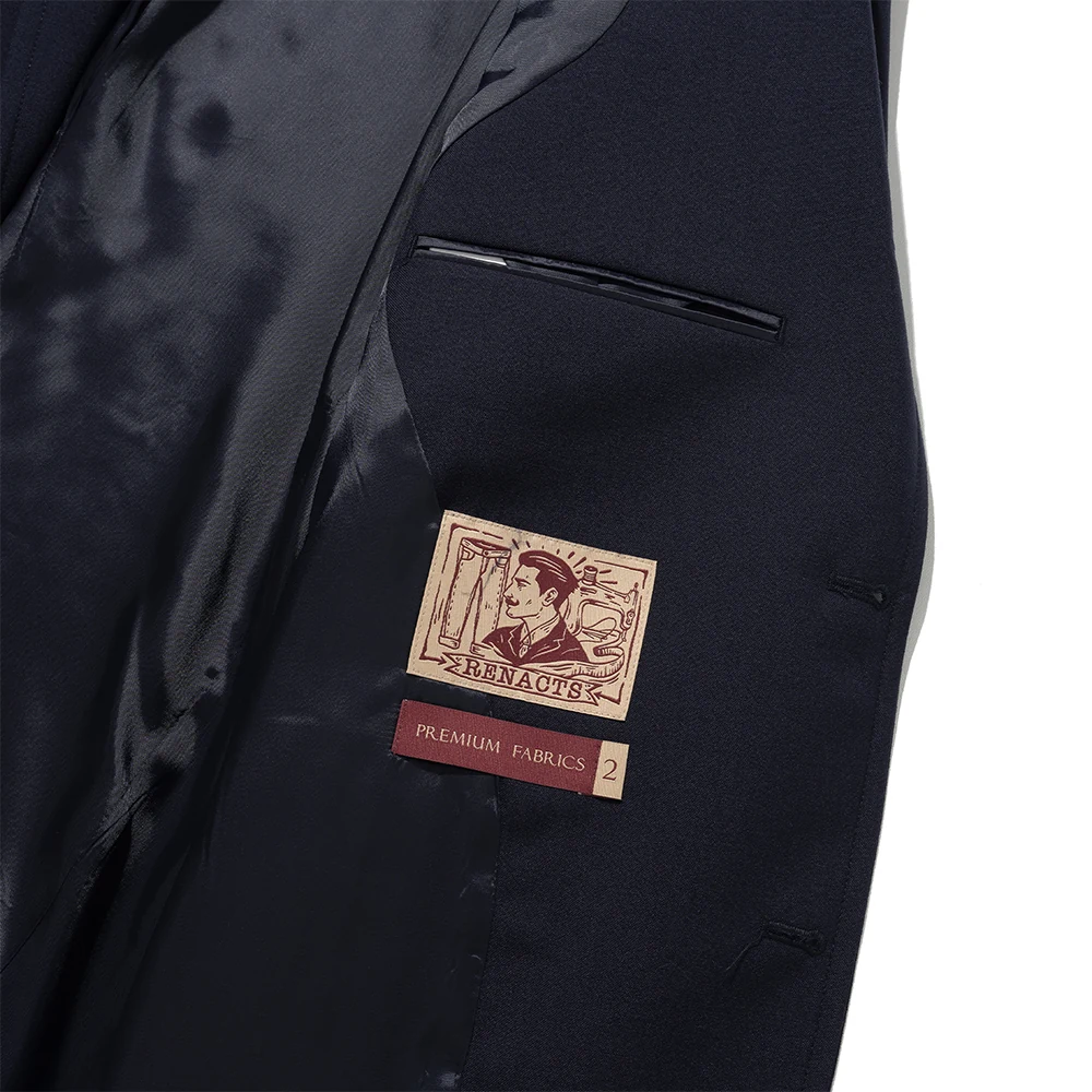 Renacts navy gold-button blazer interior label — Renacts brand crest with gentleman illustration, 'PREMIUM FABRICS' grade marker