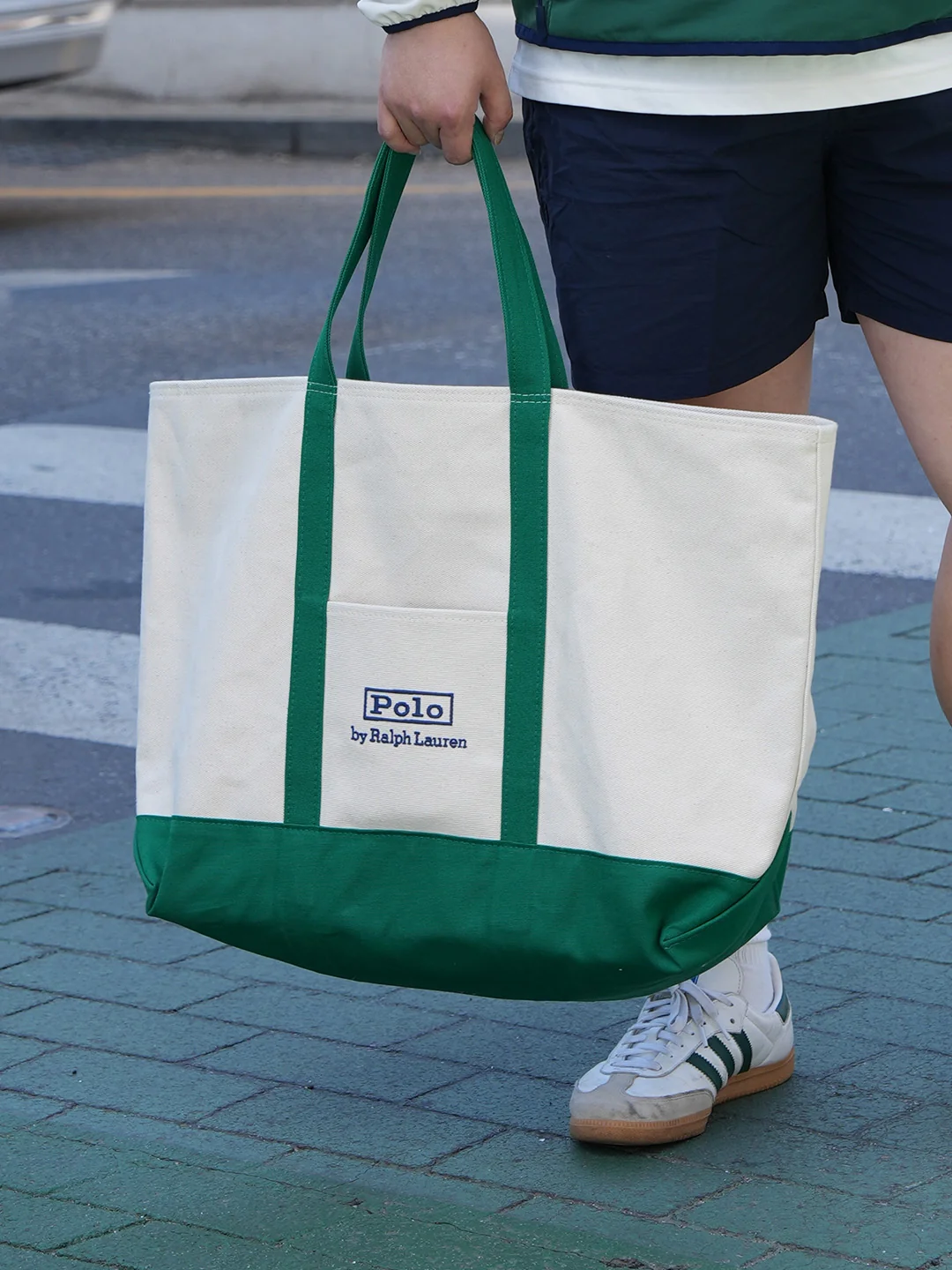 Accessory cluster — Polo Ralph Lauren ivory and green canvas tote with green handles paired with Adidas Samba white green sneakers