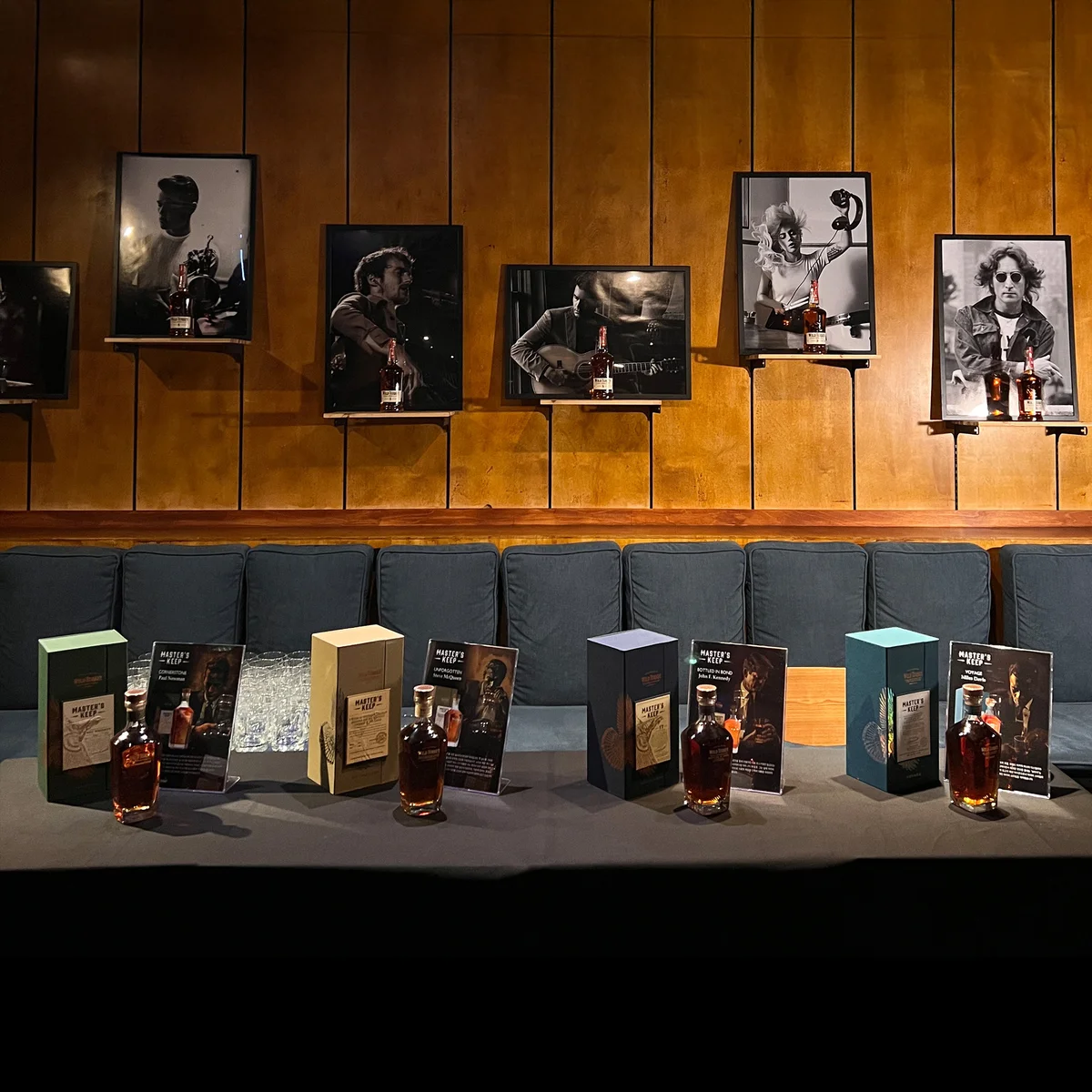 Wild Turkey lineup display — multiple boxed releases shown beneath a row of black-and-white musician portraits