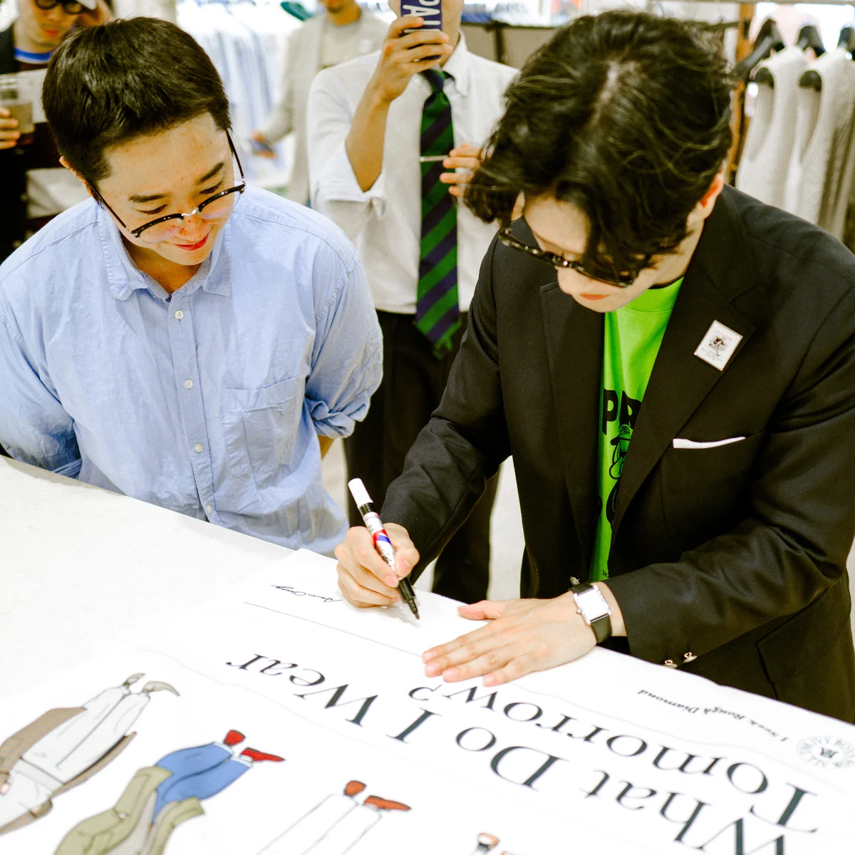 Aaron Chang signing a What Do I Wear Tomorrow collab panel up close at the J.Press × Aaron Chang Sindang-dong pop-up