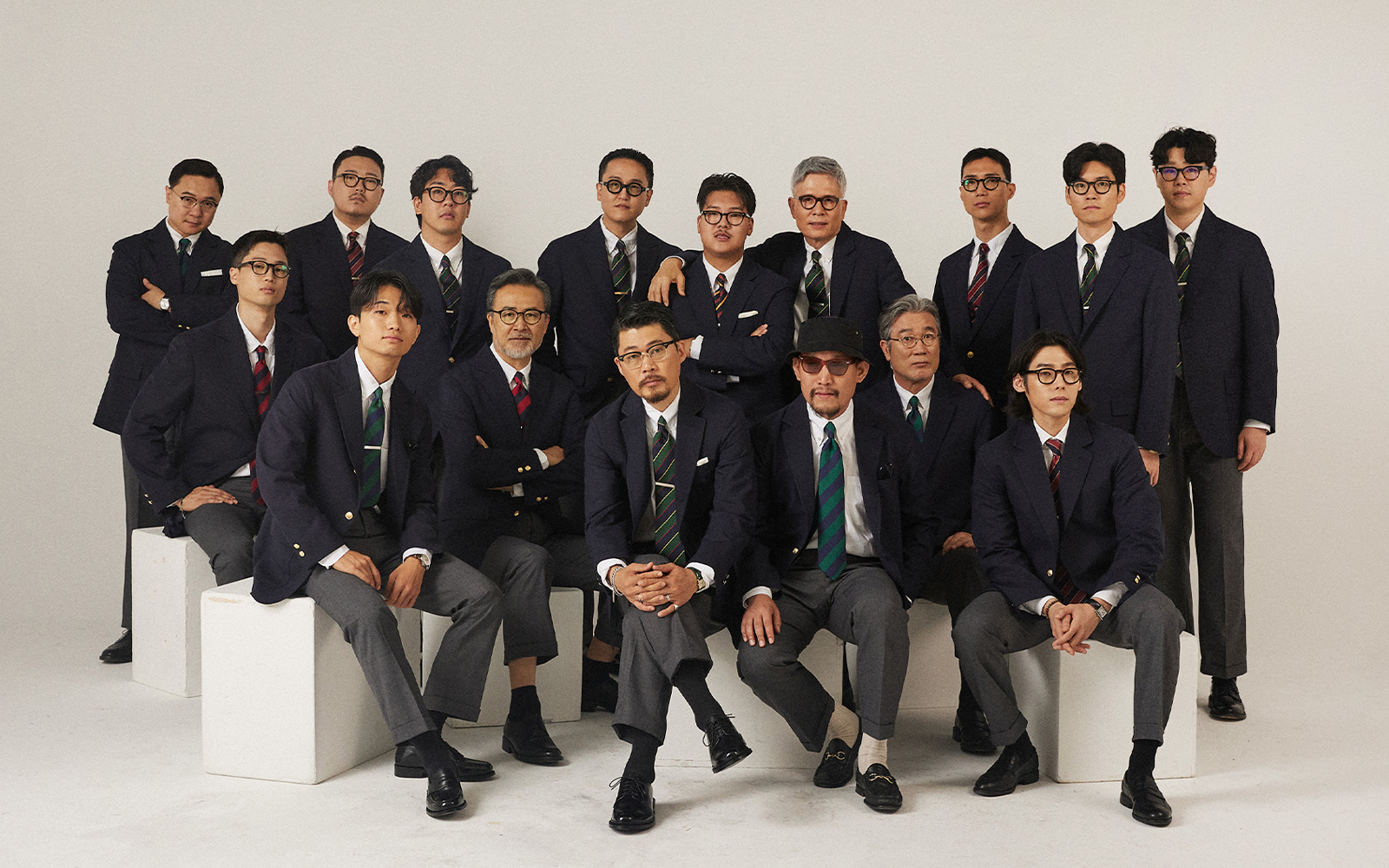 Korean Trad group portrait — navy blazer with regimental striped tie worn by Korean men in studio setting, representing the Seoul Trad register