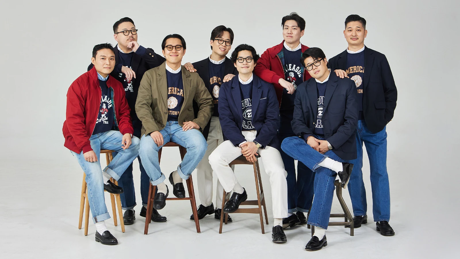 Reverse weave sweatshirt in Seoul — Gentlemens Club eight-member group portrait wearing Renacts collegiate sweatshirts under blazers and Harringtons