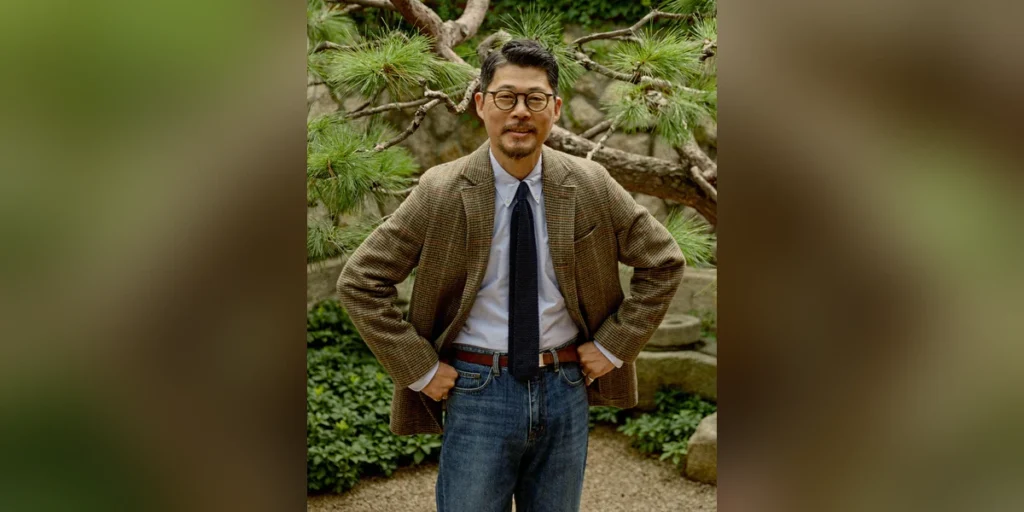 Sport coat essentials thumbnail: Renacts Gun Club tweed sport coat with white OCBD navy knit tie brown leather belt and dark denim photographed at a hanok pine garden, centered with blurred background — Saturday-tailored Trad register in Seoul
