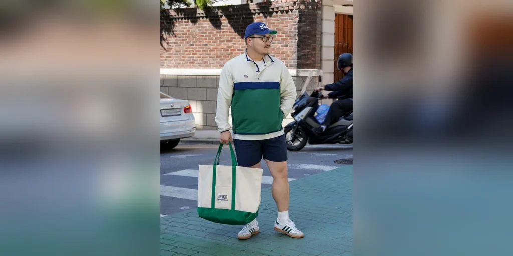Anorak shorts outfit thumbnail — Renacts bicolor anorak, navy shorts, Polo Ralph Lauren canvas tote, Adidas Samba on a Seoul side street