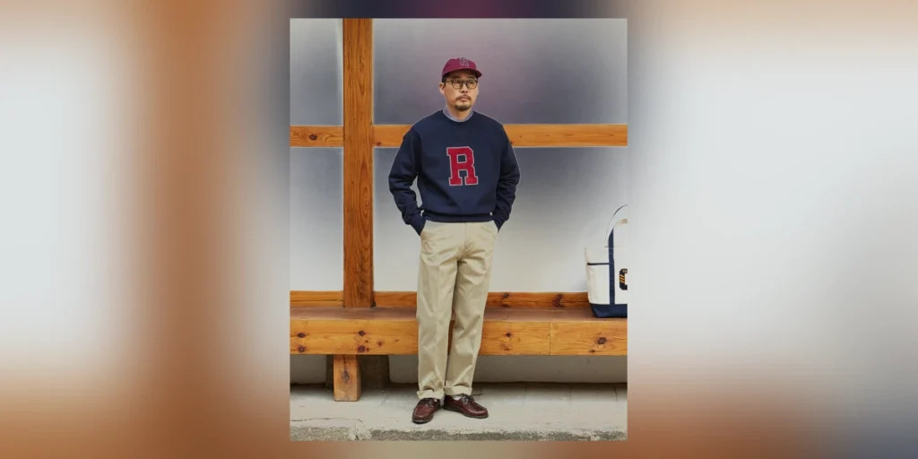 Reverse weave sweatshirt outfit — burgundy collegiate R sweatshirt over white OCBD with khaki chinos, ball cap, and brown boat shoes at a Seoul hanok