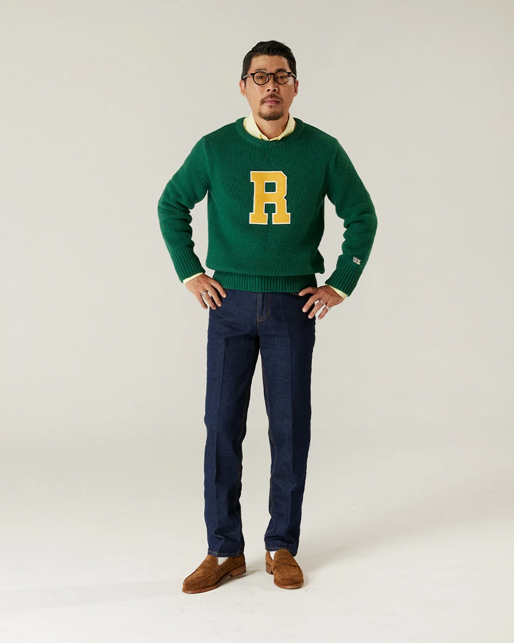 trad denim Indigo with letterman knit: white OCBD layered under varsity letterman crewneck, raw indigo Tailored Straight, suede penny loafers
