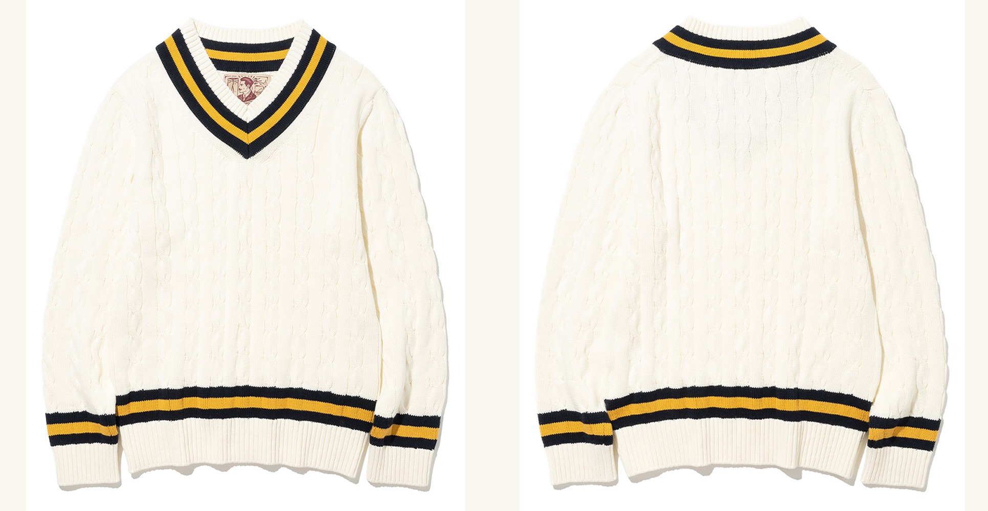 Ivory cable-knit cricket sweater laid flat, front and back side by side, with navy and yellow stripes at the V-neck, cuffs and hem