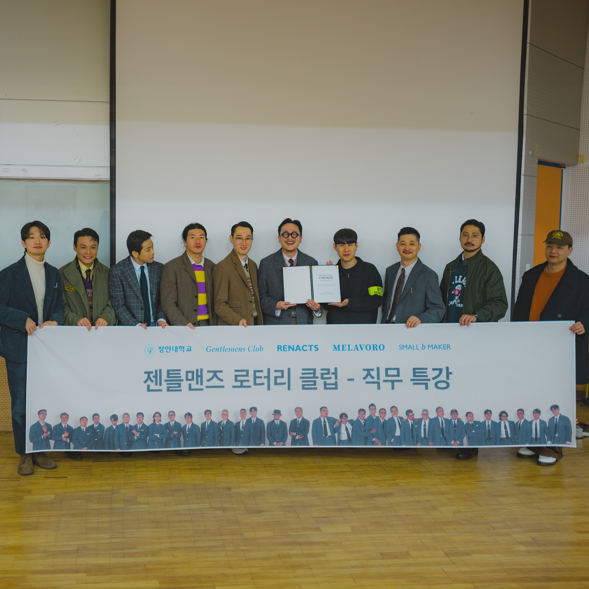 Participants holding the event banner and scholarship certificate at Jangan University.