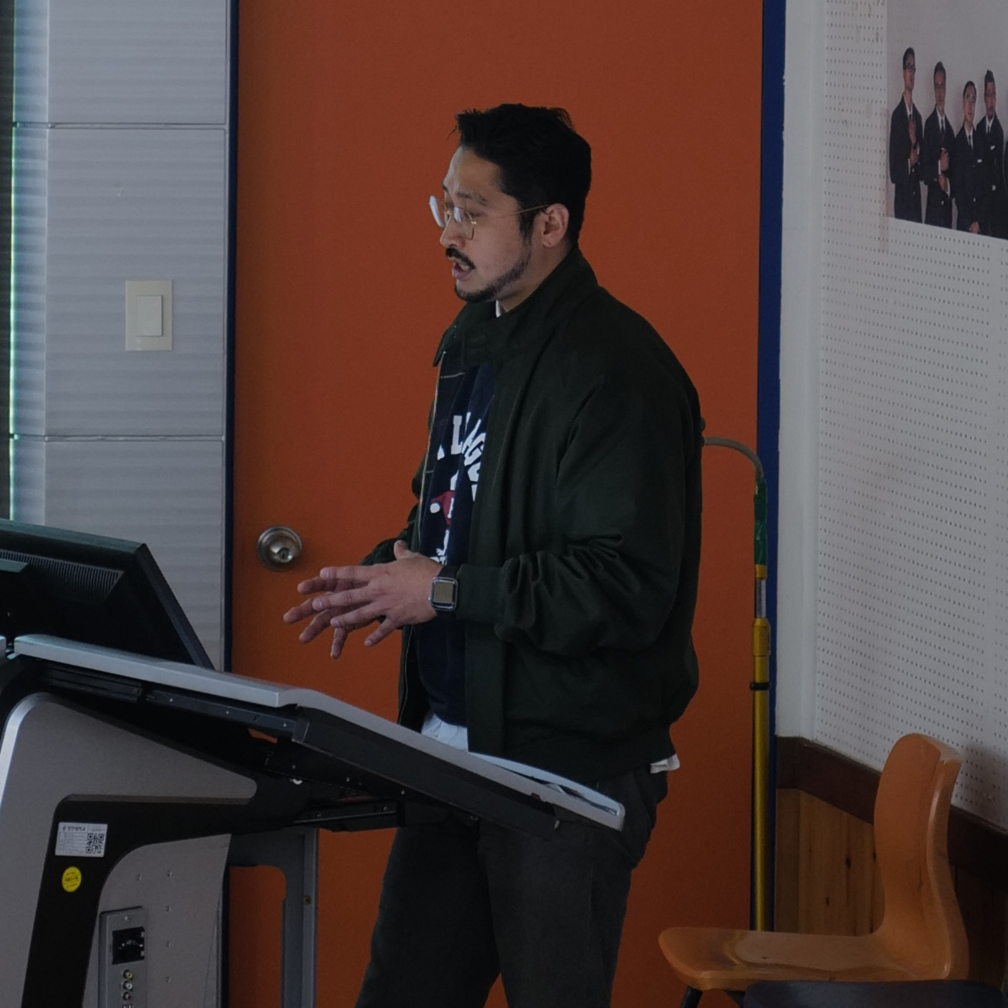 A member speaking beside the presentation screen at Jangan University.