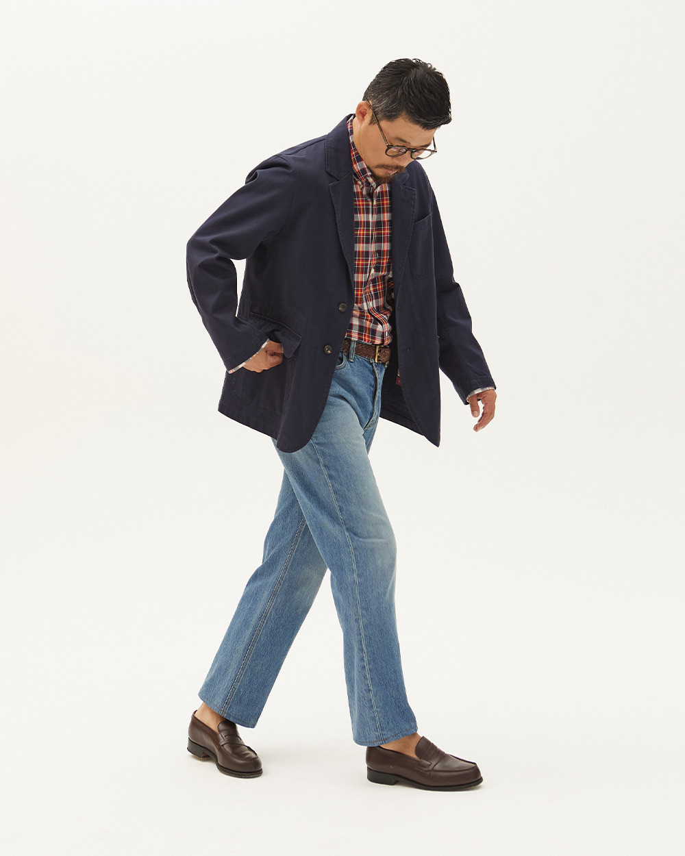 modern ivy casual: unstructured navy cotton blazer with patch pockets over a madras check shirt with faded straight-leg denim and brown penny loafers