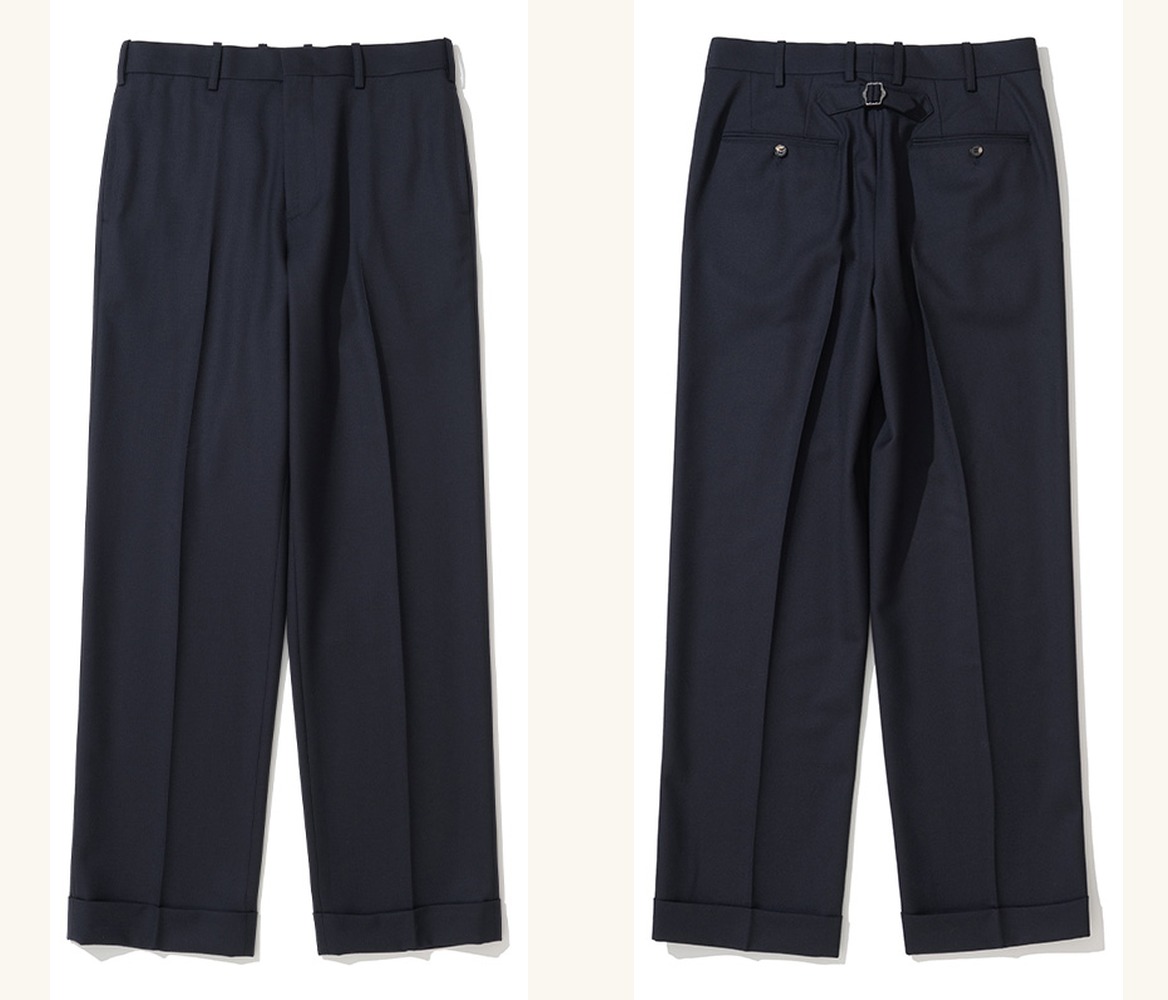 Navy wool pipe-stem trousers laid flat, front and back side by side: a flat front with turn-up cuffs, and a back with a cinch-back buckle above two welt pockets