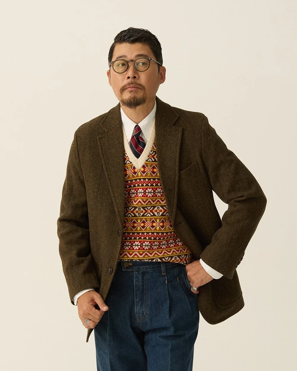 Olive brown herringbone blazer over a Fair Isle vest with dark indigo denim — Renacts FW26 lookbook