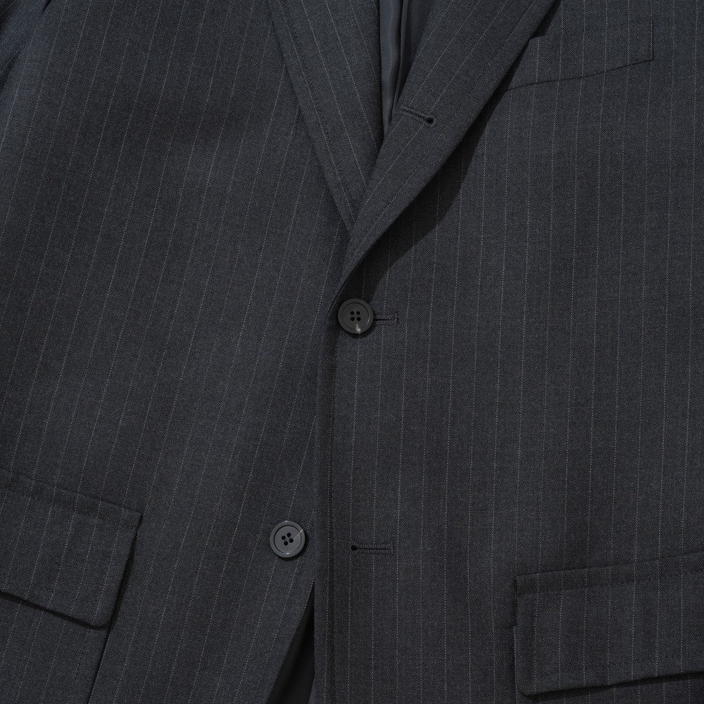 Front of a charcoal pinstripe sack jacket with the lapel rolling down to the fastened middle button, a lower button and a flap pocket below
