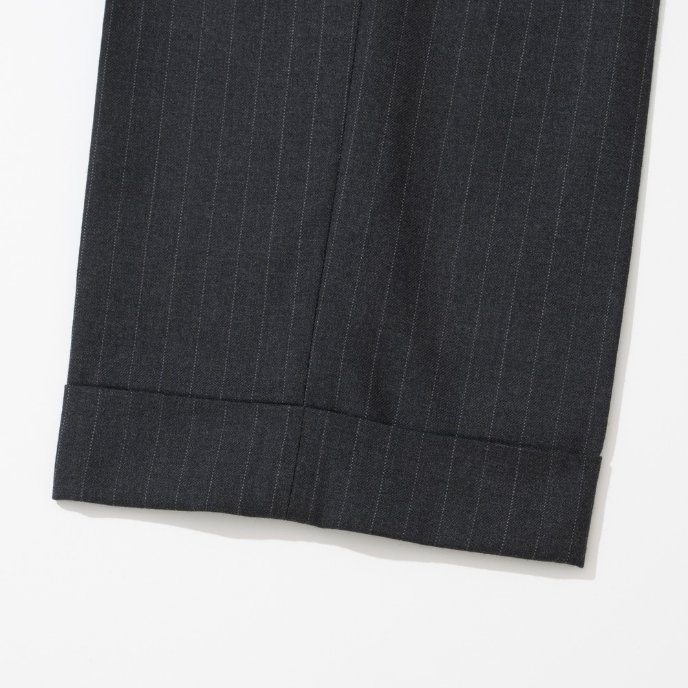 Close-up of the turn-up cuff at the hem of charcoal pinstripe trousers