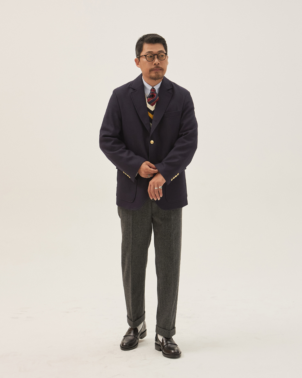 sport coat vs blazer: solid navy jacket with gilt metal buttons and patch pockets worn with grey herringbone flannel trousers, the definition of a blazer rather than a sport coat