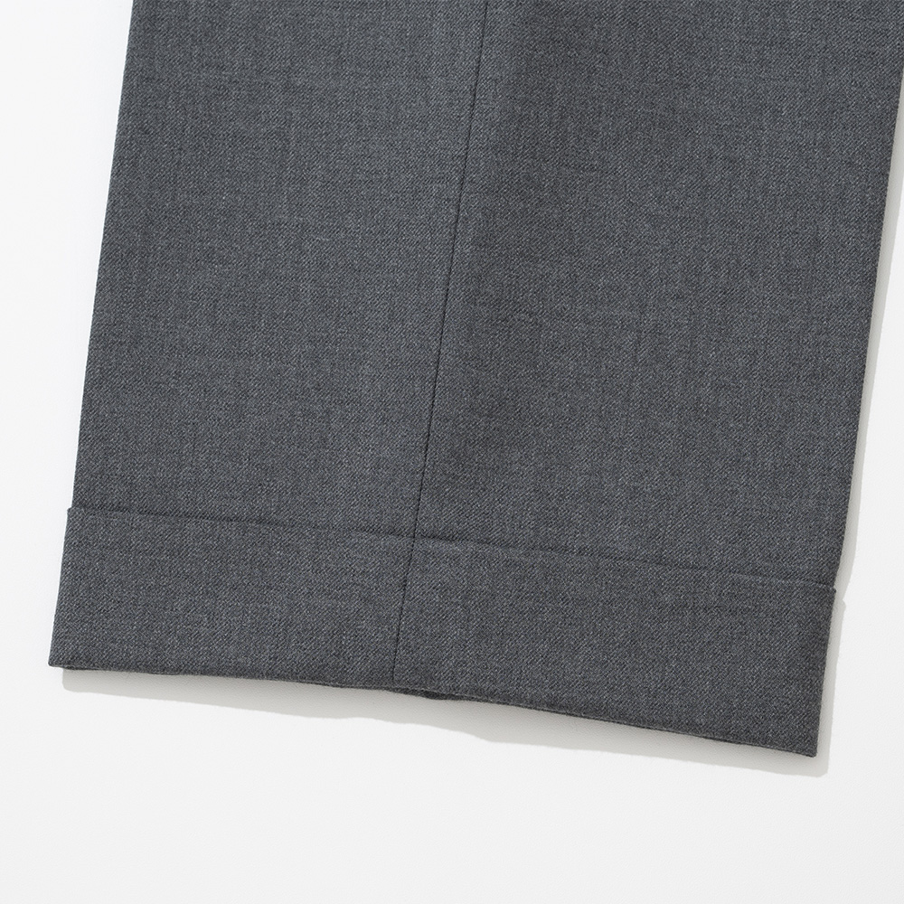 Close-up of a grey wool trouser hem with a turn-up cuff, showing the softer surface and slight nap of the wool cloth