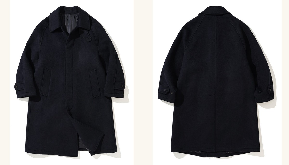 Navy brushed wool balmacaan coat laid flat, front and back side by side, with raglan sleeves and a fly front